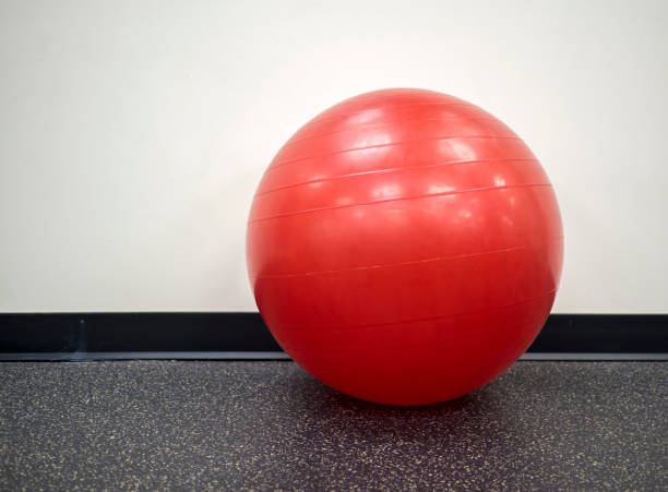 Isolated lone red exercise ball in the gym