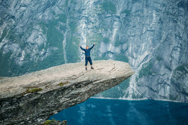 istock Man Standing On Cliff Over Lake 998162352