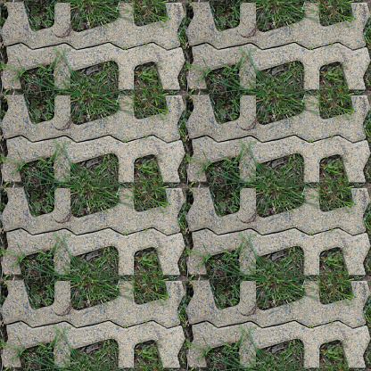 Seamless pattern with stone blocks of the original form on a park path covered and green grass