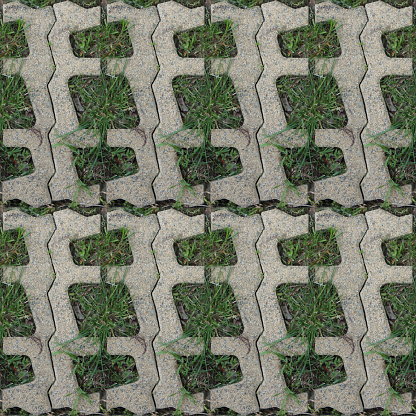 Seamless pattern with stone blocks of the original form on a park path covered and green grass