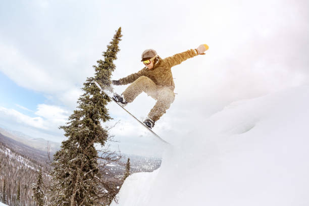 istock Snowboarder jump offpiste forest freeride 998185486