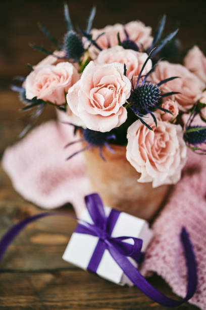 istock Mother's Day bouquet with pink roses in rustic pottery vase 998185914
