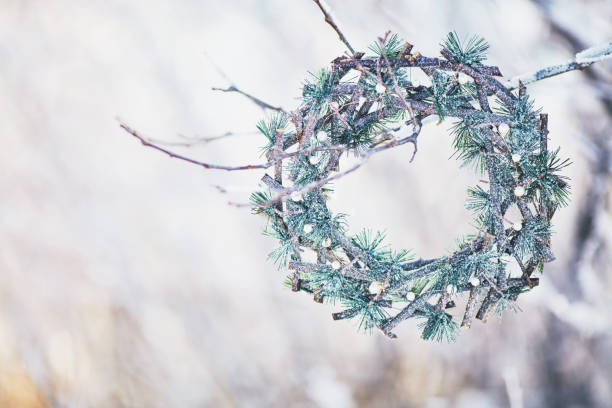Evergreen wreath hanging on snow covered branches