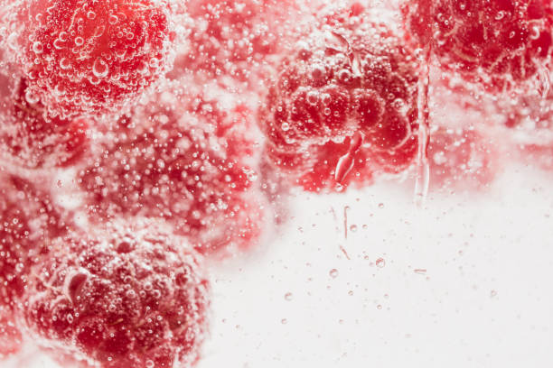 istock Fresh raspberries in water wiht air bubbles. 998192436