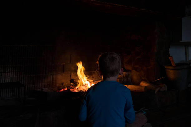 istock Youg boy sitting watching the fire 998192802