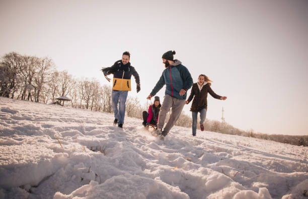 istock Young cheerful friends having fun while running on a snow. 998211088