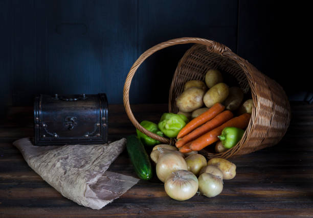 Fresh vegetable spilling out of basket.  Dark Still life concept.