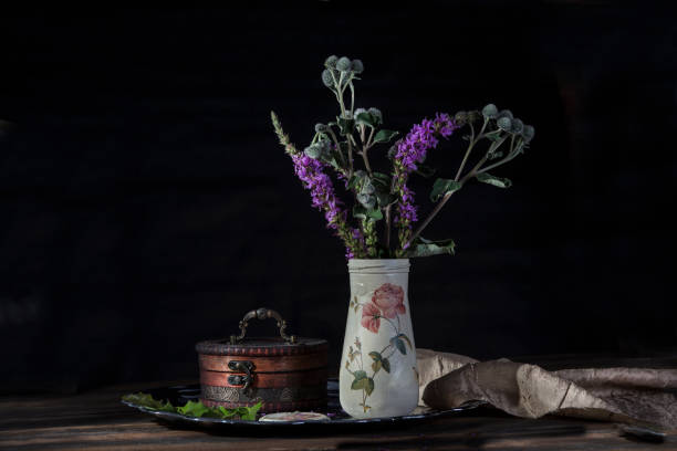 istock Dark still life with vase and flowers 998214384