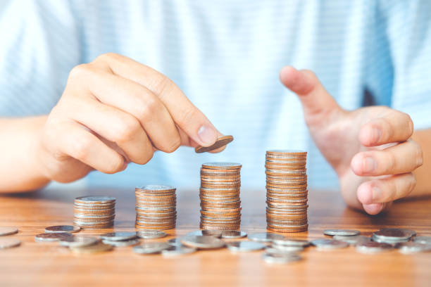 istock Saving money concept man hand putting coin stack finance for budget 998226972