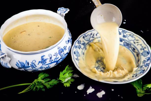 istock Pouring soup in to plate, bowl and spilled background. 998230552