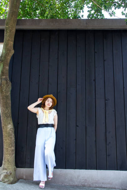 istock Young asian woman standing by the black wall. 998234680
