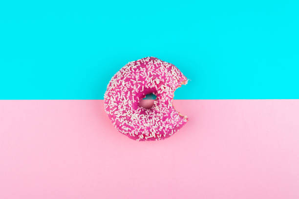 istock one pink isolated donut on a mint and pink background 998237764