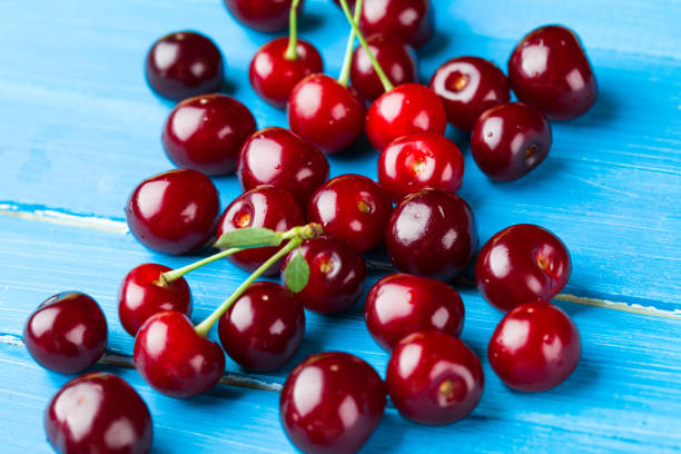istock Cherries on wooden background 998238076
