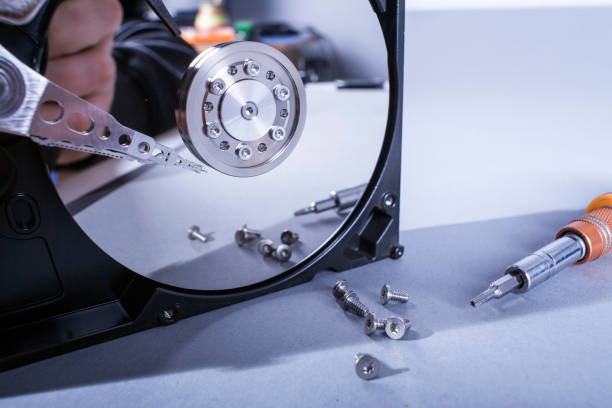 istock Hard disk drive platter. Open hdd hard disk. Data recovery from damaged media. Disk head above the plates 998256454