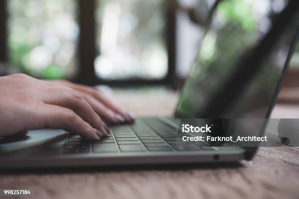 Closeup Image Of A Womans Hands Working And Typing On Laptop Keyboard On Wooden Table Stock Photo - Download Image Now