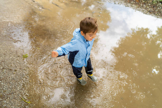 istock dirty rain puddle little boy from above 998271800