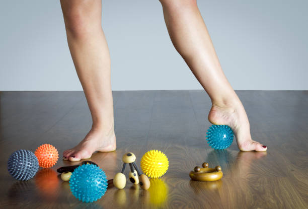 danseur de ballet, massant son pied avec un ballon bleu pour massage - massage ball photos et images de collection