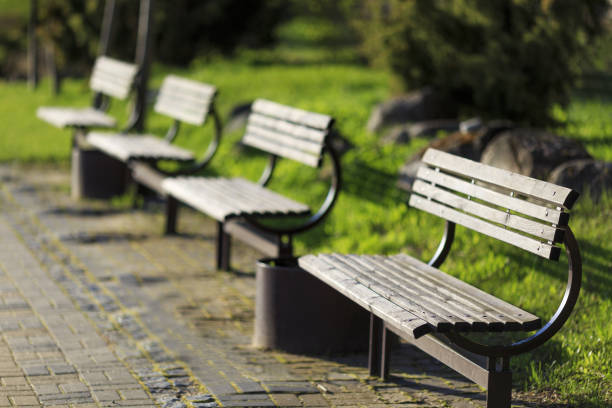 istock Four wooden empty benches in a row. Focus on foreground bench, benches arranged by frame diagonal. 998279352