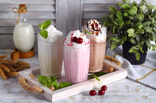 milkshakes with whipped cream, cherries, chocolate and mint