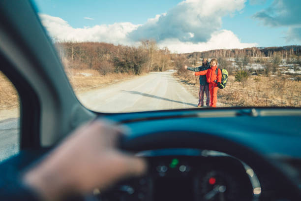 Travelers hitchhiking Young couple on the roadside waiting for car to stop hitchhiking stock pictures, royalty-free photos & images