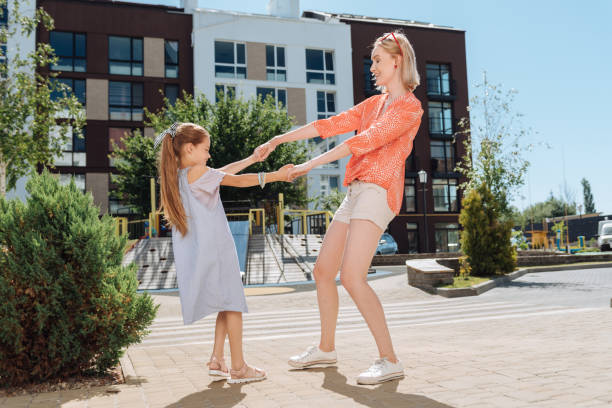 istock Delighted young woman holding her daughters hands 998290420