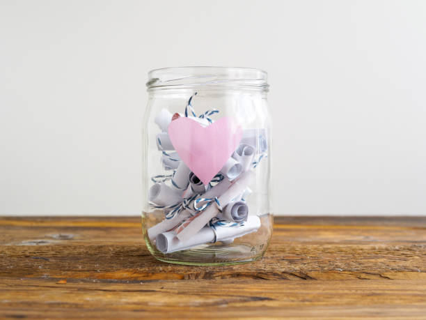 istock Jar with roas heart and rolled up notes 998297354