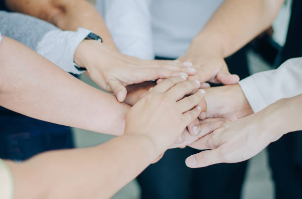 istock Group of business people putting their hands together teamwork join hands , Unity and teamwork concept 998302170