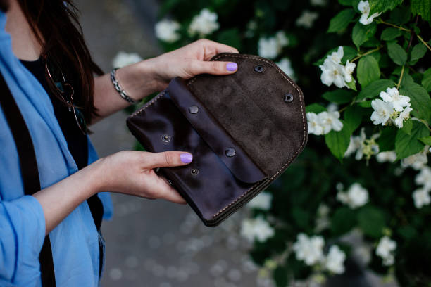 istock Girl holding a brown money wallet. 998306894