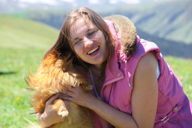 istock A woman playing with a little red dog 998306910