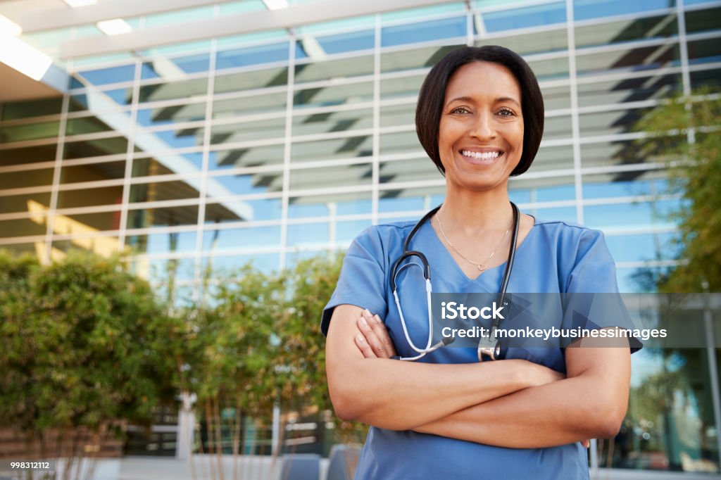 Smiling mixed race female healthcare worker outside hospital Nurse Stock Photo