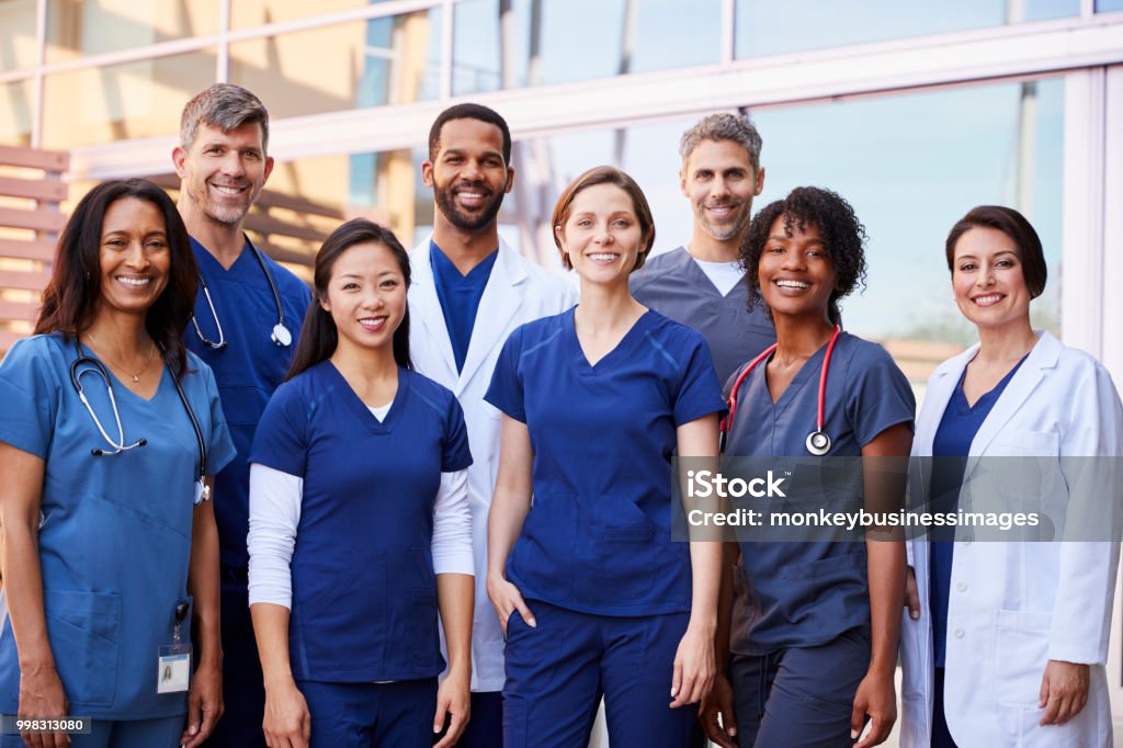 Smiling medical team standing together outside a hospital Nurse Stock Photo