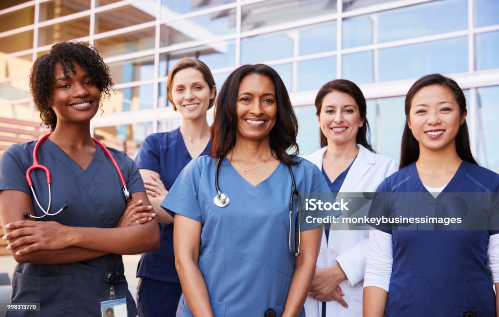 Kvinnliga hälso-och kollegor står utanför sjukhus - Royaltyfri Sjuksköterska Bildbanksbilder
