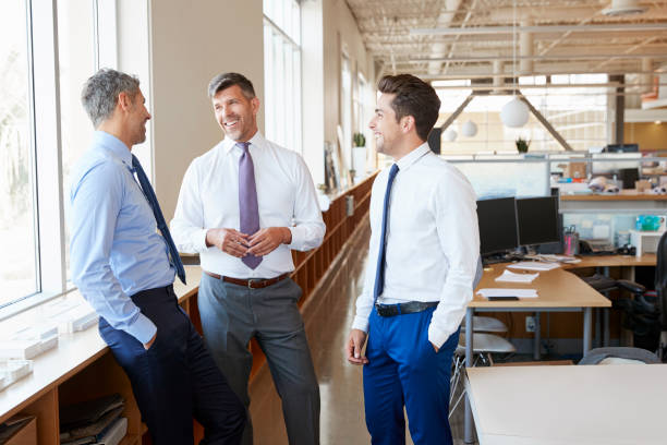 istock Three male corporate business colleagues chatting at work 998318160
