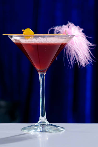 istock Alcoholic pink cocktail in a martini glass with straw, shallow d 998318176