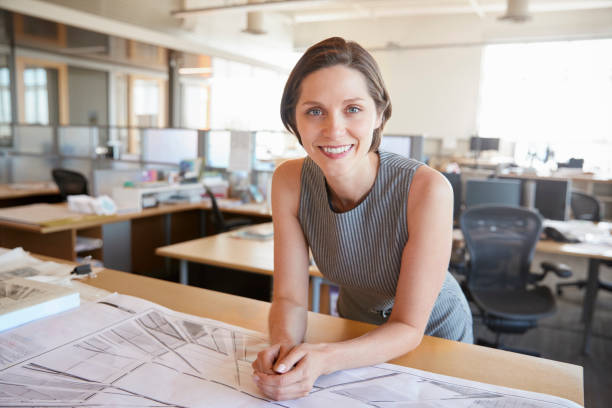 istock Young female architect leaning on desk smiling to camera 998321706