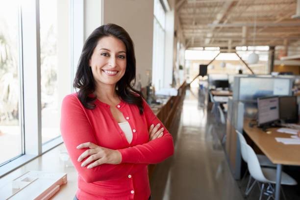 Female Hispanic architect smiling to camera in an office Female Hispanic architect smiling to camera in an office latin woman stock pictures, royalty-free photos & images