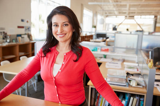 istock Female architect smiling to camera in open plan office 998324834