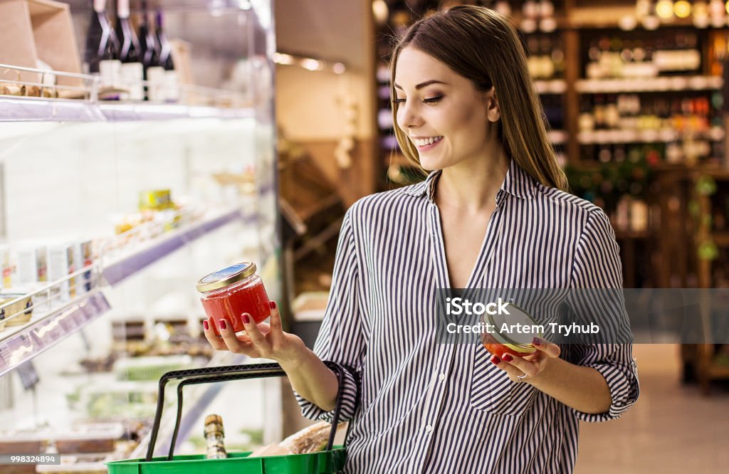 Mujer elegir caviar rojo en supermercado de pescado - Foto de stock de Supermercado libre de derechos