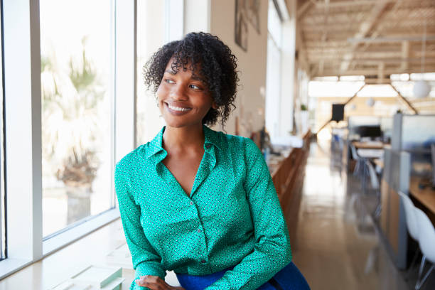 istock Young black female architect looking out of office window 998327028