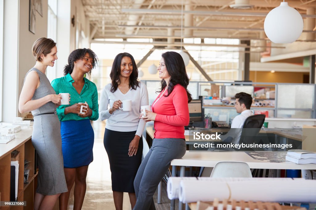 Colegas de trabalho feminino, conversando sobre o café no escritório - Foto de stock de Mulheres royalty-free