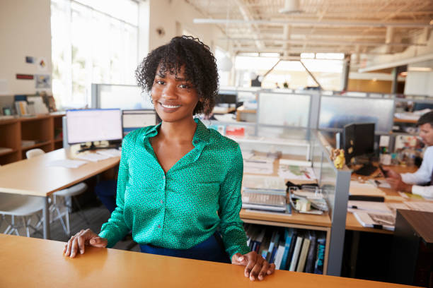 istock Black female architect in open plan office smiling to camera 998329128