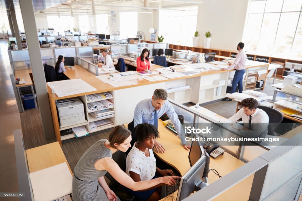 Kollegen, die an einem Frauenarbeitsplatz in einem geschäftigen Büro arbeiten - Lizenzfrei Büro Stock-Foto