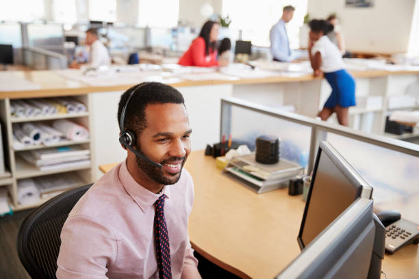 istock Smiling black male call centre worker looking at screen 998336762