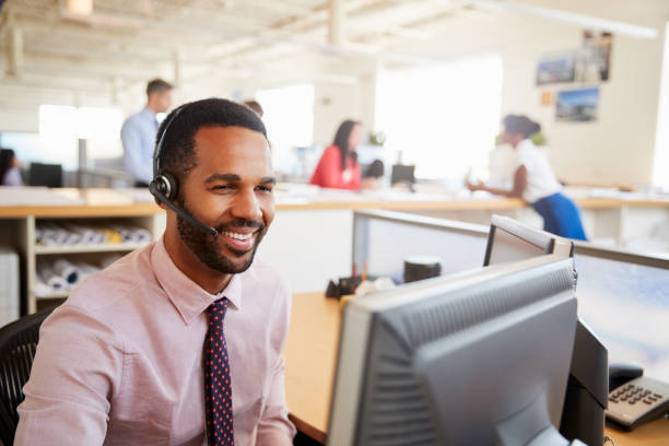 istock Smiling male call centre worker looking at screen, close-up 998336864