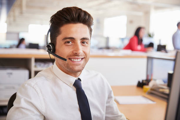 istock Hispanic male call centre worker smiling to camera, close-up 998336974