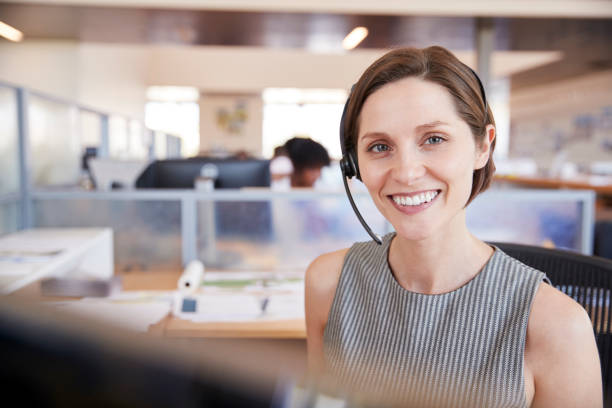 istock Young white woman working in a call centre smiling to camera 998337566