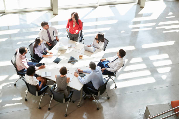 Businesswoman addressing team meeting, elevated view Businesswoman addressing team meeting, elevated view business meeting stock pictures, royalty-free photos & images