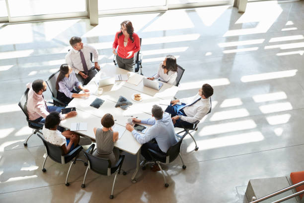 businesswoman addressing team meeting, elevated view - teamwork conference team business meeting imagens e fotografias de stock