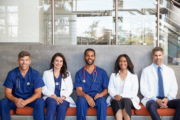 Healthcare workers sitting in hospital, three quarter length Healthcare workers sitting in hospital, three quarter length lab coat photos stock pictures, royalty-free photos & images