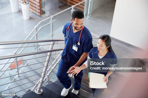 Two Healthcare Colleagues Talking On The Stairs At Hospital Stock Photo - Download Image Now